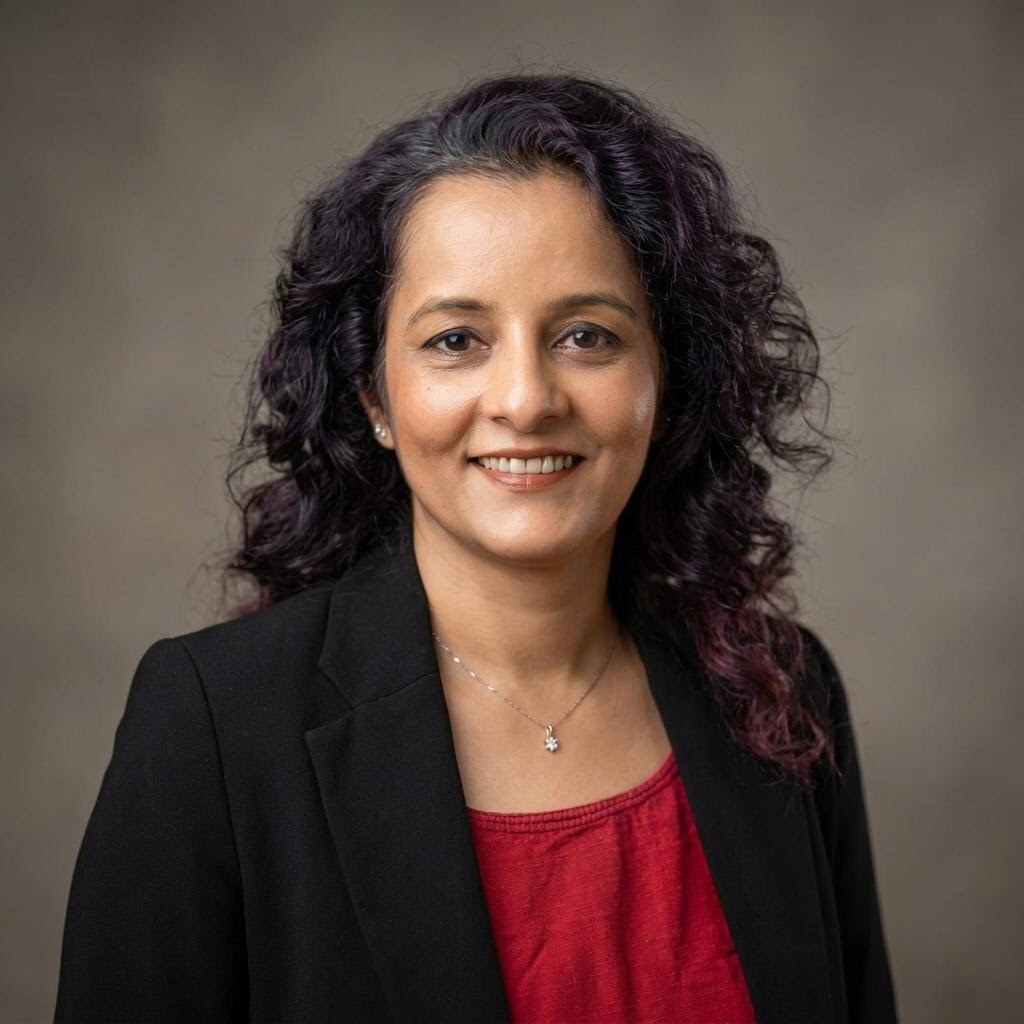 Alpa Parmar, founder of Bots and Brand Works, in a black blazer and red blouse