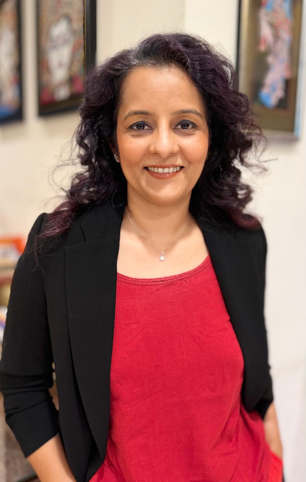 Alpa Parmar, founder of Bots and Brand Works, in a black blazer and red blouse