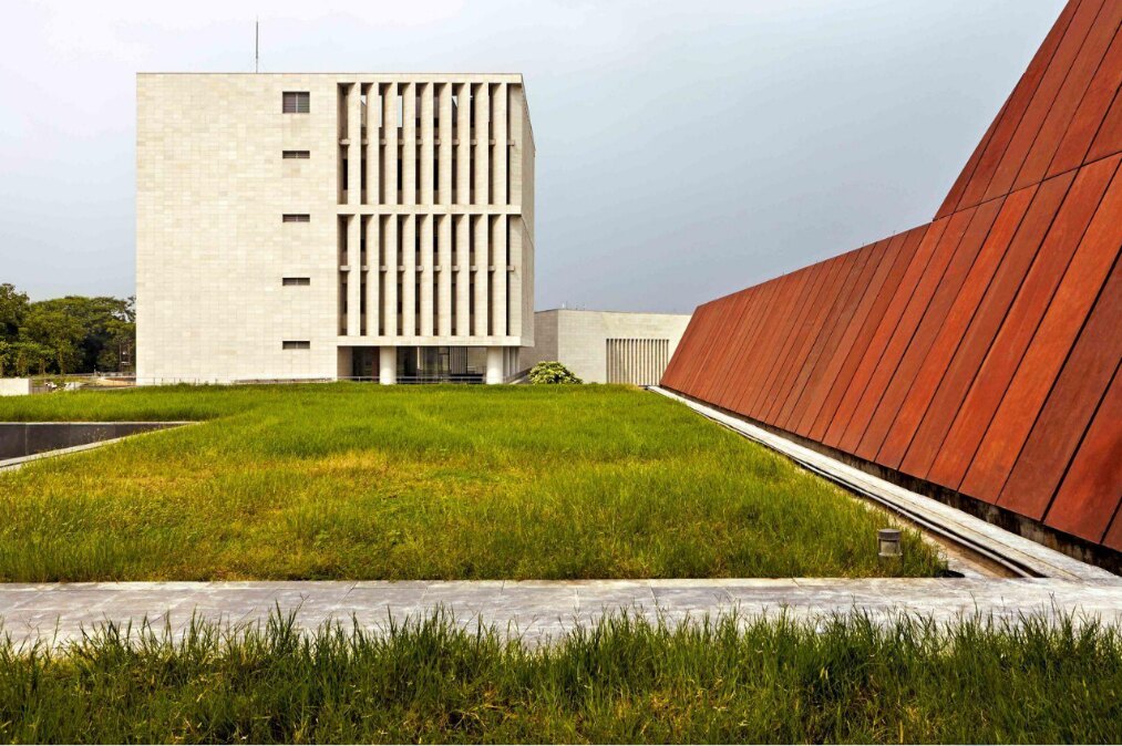 Bihar Museum’s modern exterior, with a rust-coloured wall beside landscaped lawns