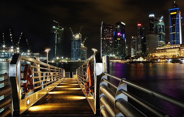 Boarding a Singapore River night cruise beside illuminated waterfront buildings