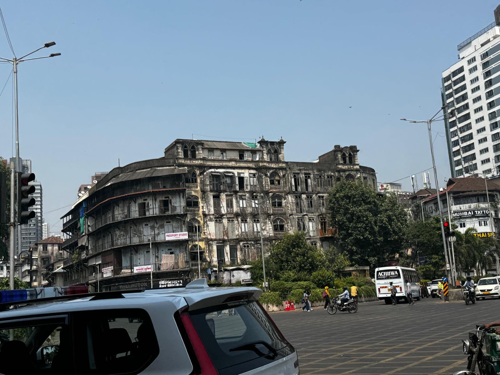 Older Mumbai buildings at a busy road junction alongside newer construction