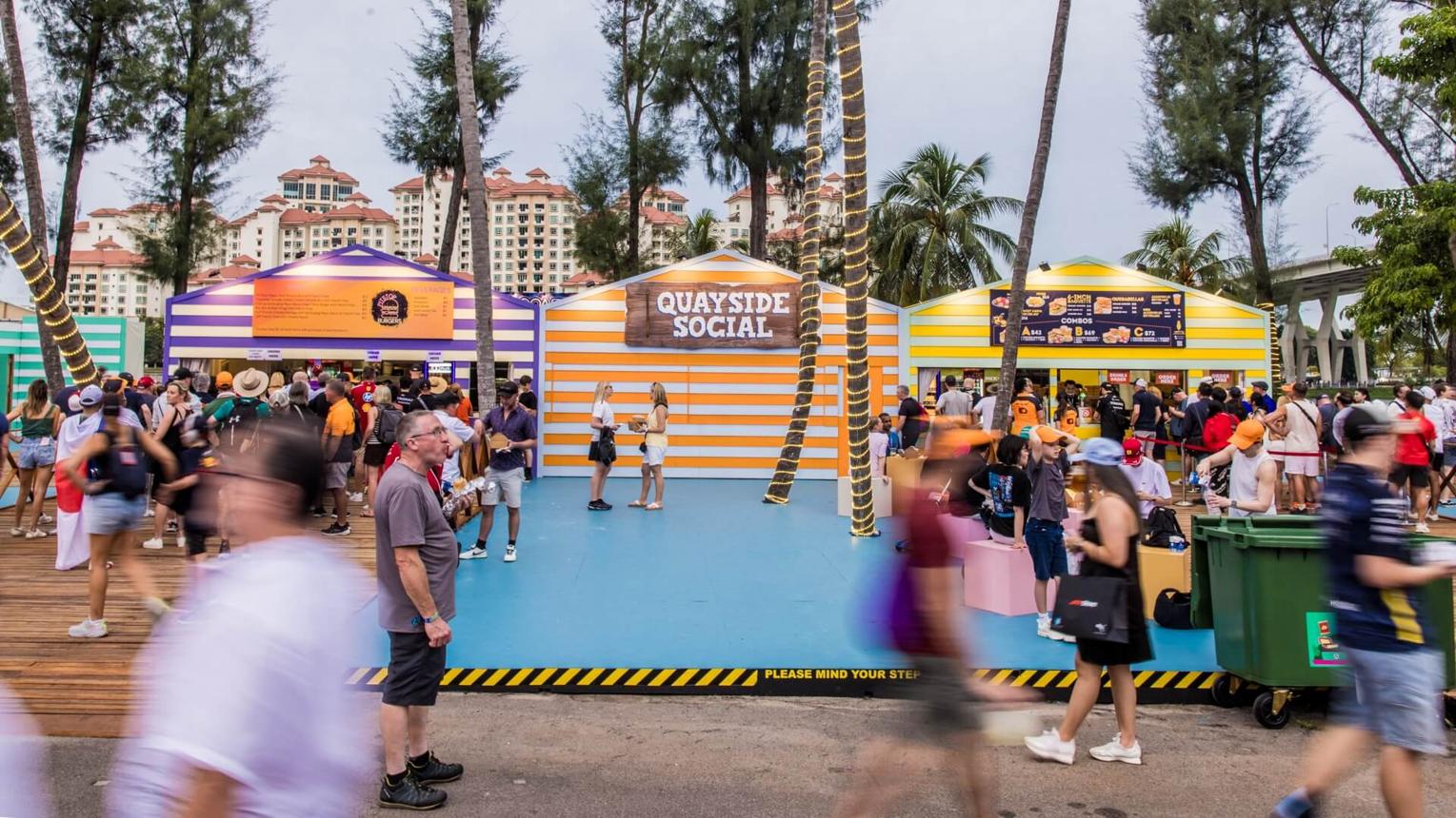 Food stalls and visitors in a Grand Prix social area